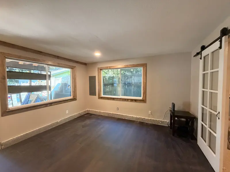 Room with new dark plank flooring and stained window trim