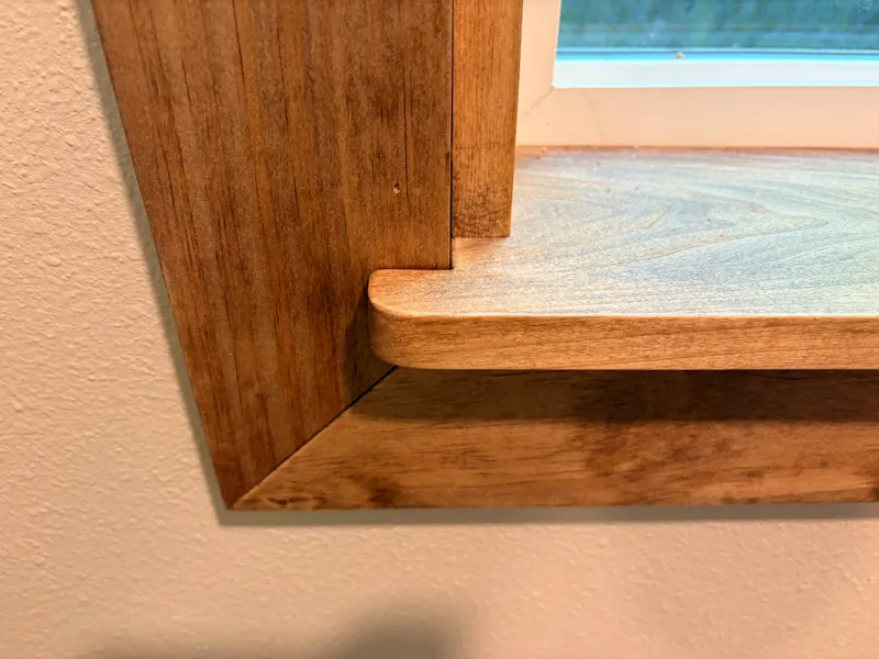 Close-up of a stained window sill and mitered casing corner