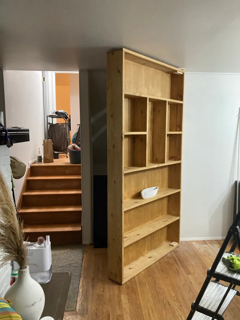 Finished wood bookcase installed beside a staircase