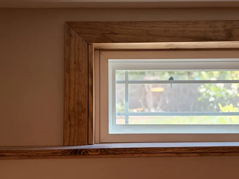 Stained wood casing around a basement window